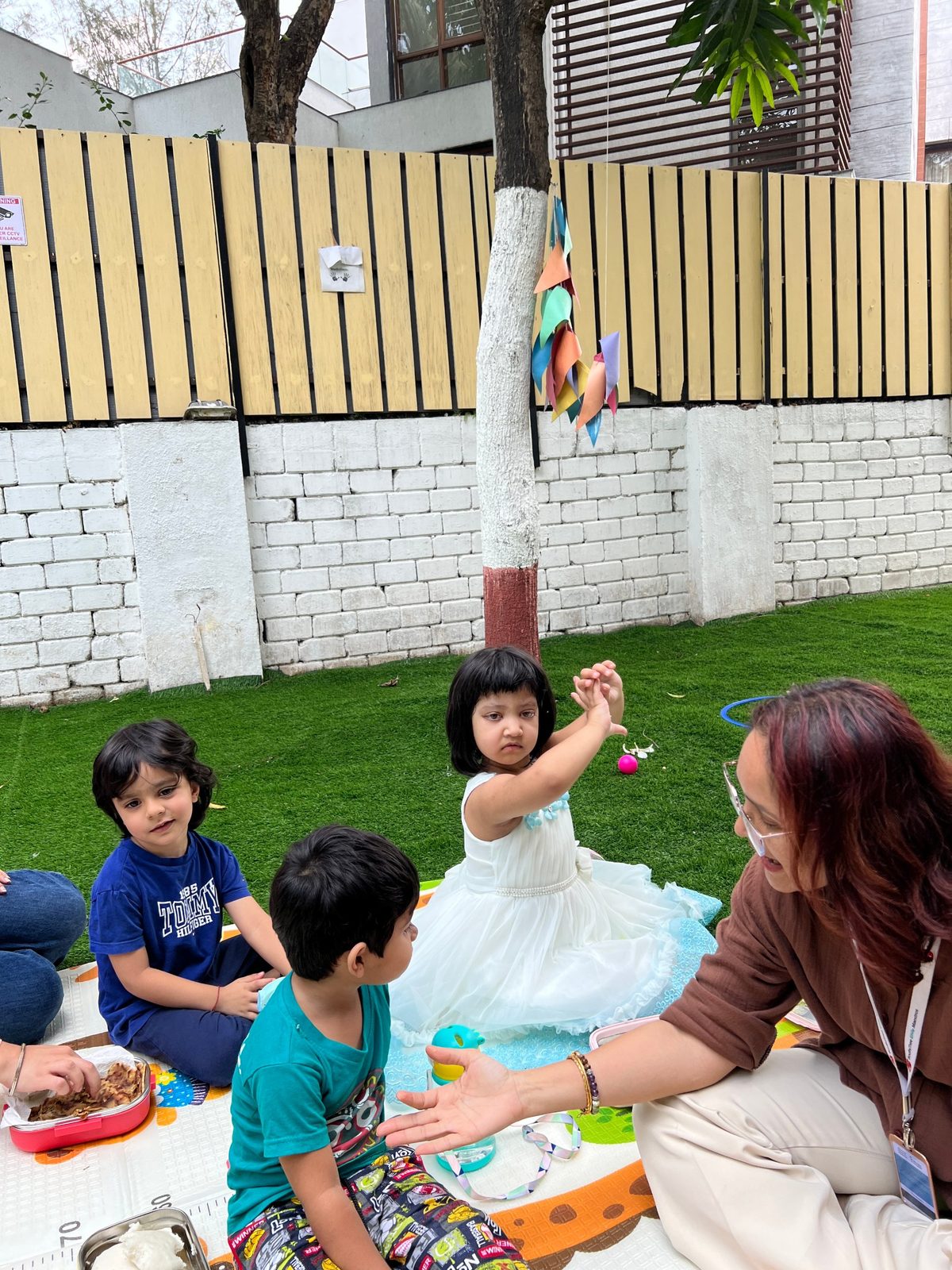 Children in garden circle time with a teacher